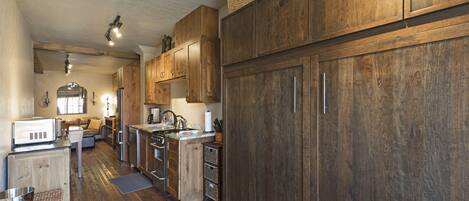 A kitchen with wooden cabinets, a microwave, and a sink.