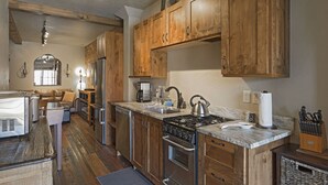 A kitchen with wooden cabinets, stainless steel appliances, and a marble countertop.