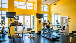 A gym with treadmills, elliptical machines, and weight stations.