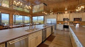 A spacious kitchen with a large island, stainless steel appliances, and a view of the mountains.