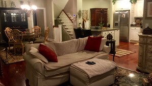 A living room with a sofa, a dining area with chairs, a kitchen with a refrigerator, and a staircase. - 3+ acres of woods and lake (Bremen)