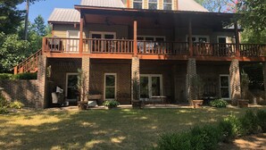 A two-story house with a balcony, brick exterior, and a covered patio area. - 3+ acres of woods and lake (Bremen)