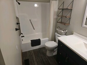 A bathroom with a bathtub, toilet, and a vanity with a mirror. - Serenity In The Smokies, Great View, great locatio (Sevierville)