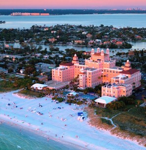 A coastal hotel with multiple buildings, a beachfront, and a marina.