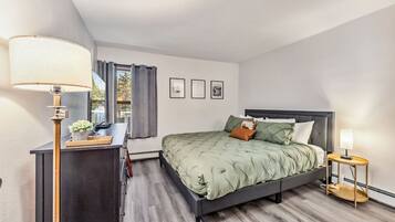 2 habitaciones, escritorio y tabla de planchar con plancha