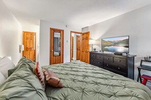 2 habitaciones, escritorio y tabla de planchar con plancha