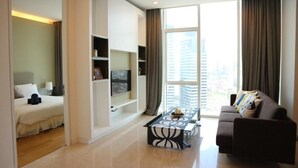 Una sala de estar moderna con un sofá, una mesa de centro y un televisor sobre una estantería.