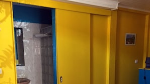 Une chambre avec un lit, une salle de bain avec une douche et un placard bleu.