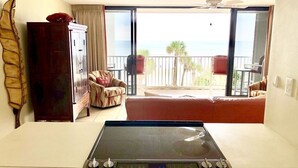Ein Zimmer mit Meerblick, einem Esstisch, einer Couch und einem Schrank.