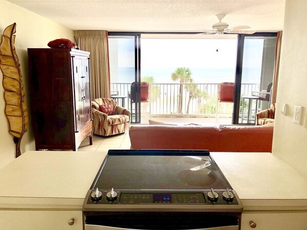 Una habitación con vista al océano, una mesa de comedor, un sofá y un armario.