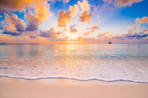 A beach with calm waters and a sunset. - PREMIER LUXURY~FREE Golf & Activities ~Golf Cart~Hot tub, Pool, Gym (Miramar Beach)