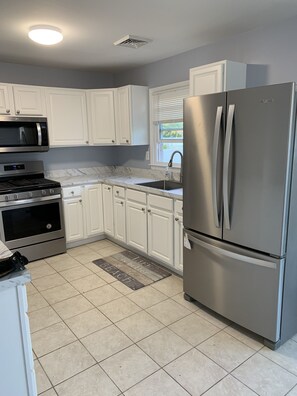 Enjoy cooking in this well-equipped kitchen with a refrigerator, microwave, and gas range.