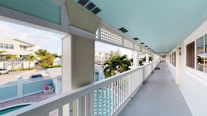 Stroll through the hotel's corridor, taking in the view of the street outside with its parked cars and nearby buildings.