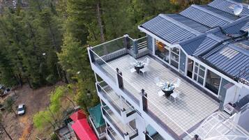 Ein mehrstöckiges Gebäude mit Dachterrasse, Sitzgelegenheiten im Freien und einer Satellitenschüssel.