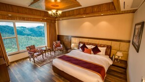 A spacious bedroom with a large bed, wooden flooring, a view of the outdoors, and a chandelier. - The Retreat Mashobra, Shimla (Shimla)