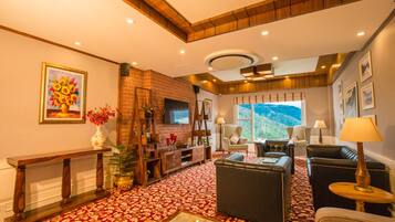 A spacious living room with a fireplace, comfortable seating, and a large window offering a scenic view.