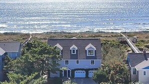 A coastal residential area with houses, a pier, and a view of the ocean. - Jonah's Whale: Large Oceanfront Home, Ocean and Waterway Views (Caswell Beach)