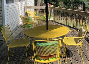 A wooden deck with yellow metal chairs and a round table. - Lakehouse, Sleeps 6, Private Dock, Infinity Beach Pit, 2 Kayaks! (Hawkins)