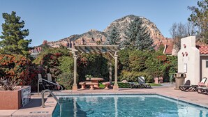 A pool area with a pergola, lounge chairs, and a view of mountains. - Jewel House West Sedona with Private Hot Tub! (Sedona)