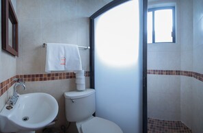 Een badkamer met een wastafel, toilet en raam.