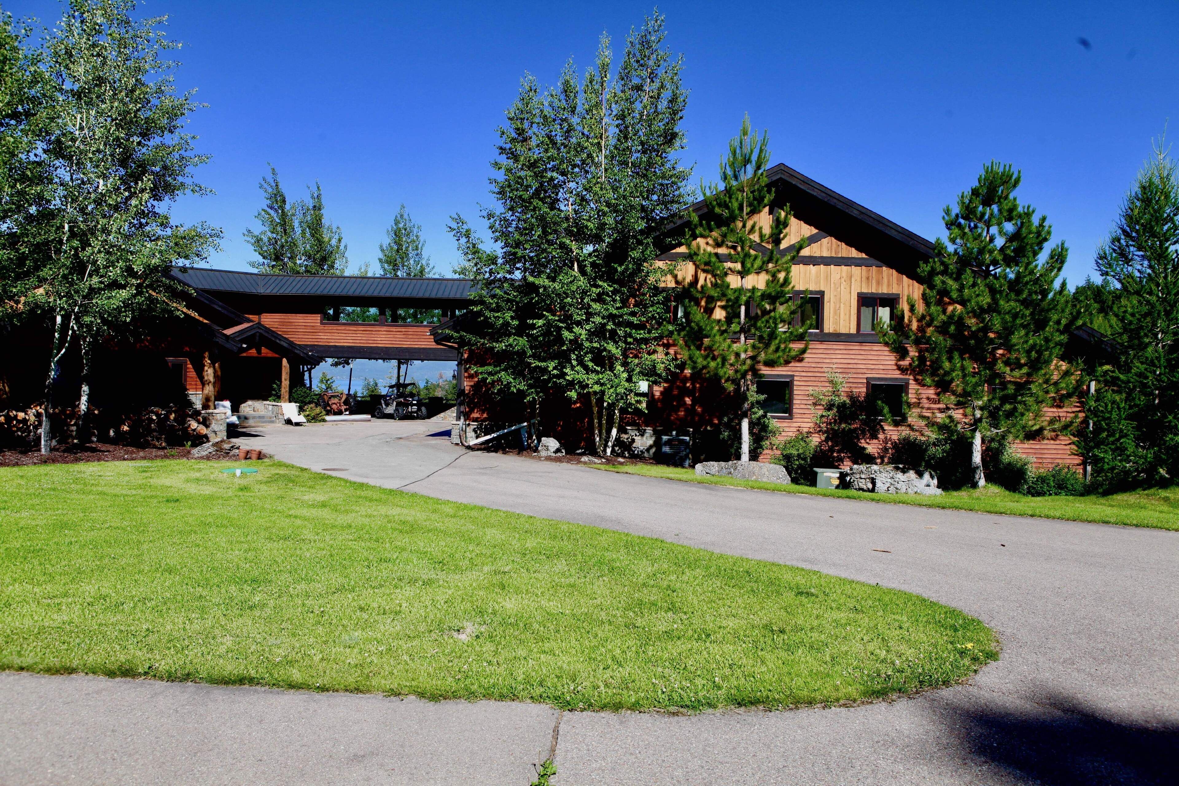 A modern building with a covered entrance, surrounded by well-maintained grass and trees.
