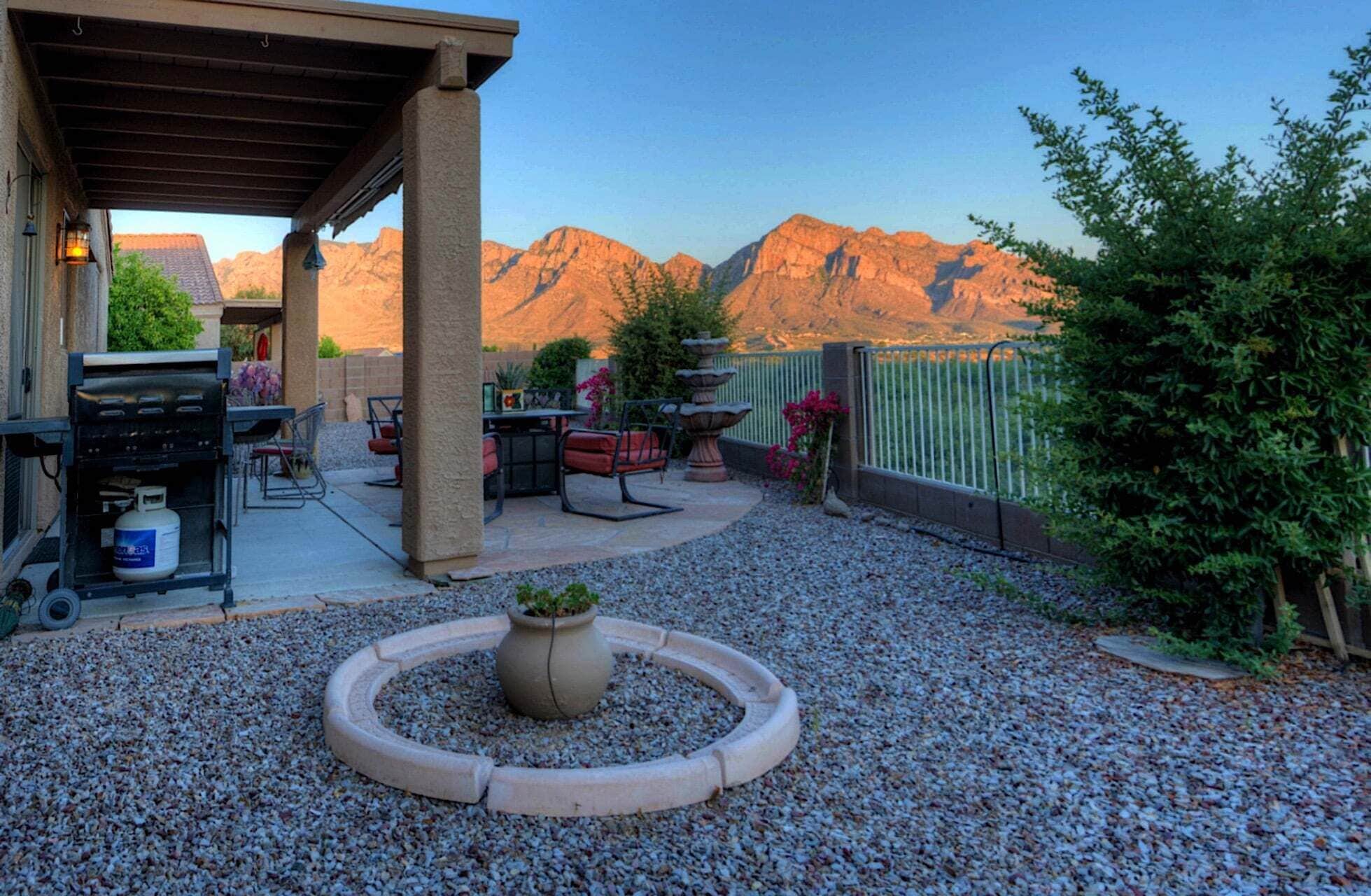 A patio with outdoor furniture, a gas grill, and a decorative planter.