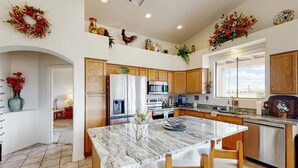 A kitchen with a marble island, wooden cabinets, stainless steel appliances, and decorative wreaths. - Mountain Calling spectacular views/ Spacious 3 BR Home/ Oro Valley/ Tucson (Tucson)