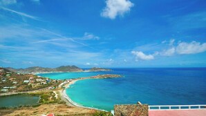A coastal view with a clear sky, turquoise waters, and a stone building with a red roof. - 🌴Joy Estate by IRE Vacations - Expansive Property with Amazing Views ☀️ (Cay Hill)
