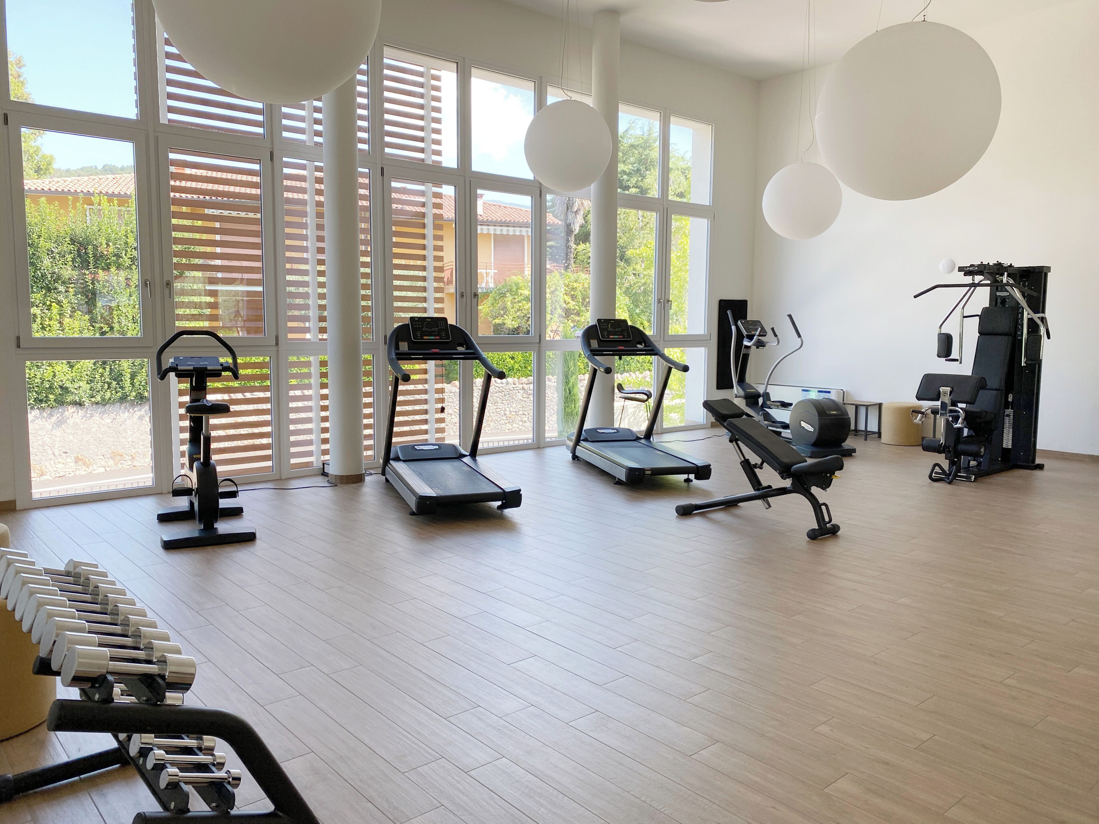 Un gimnasio con cintas de correr, mancuernas y una máquina de pesas.