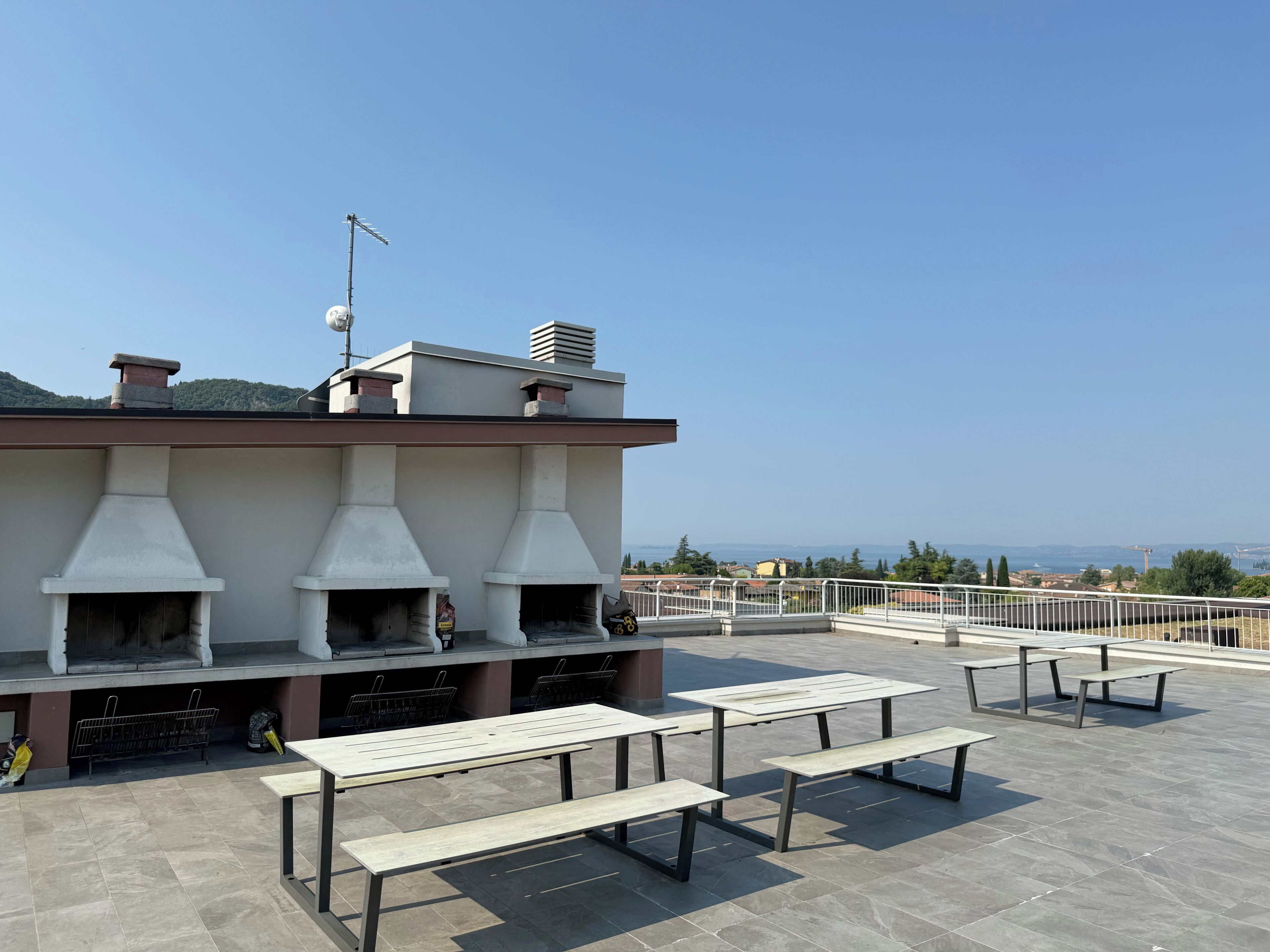 A rooftop terrace with outdoor seating and a stone oven.