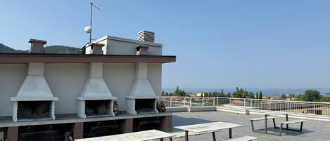 A rooftop terrace with outdoor seating and a stone oven.