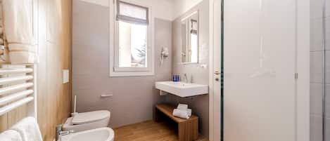 Egy modern fürőszoba, amelyben kád, mosdókagyló és WC található.
