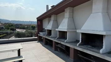 Une terrasse sur le toit avec des espaces de détente en plein air et un coin barbecue.