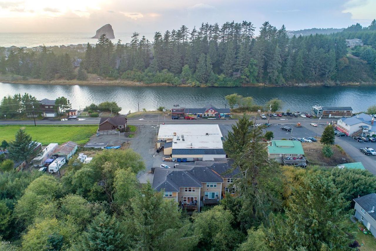 An aerial view of a lakeside community with residential buildings, a parking lot, and a boat dock.