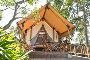 A tented accommodation with a wooden deck, a table, and chairs. - The Park - Silang (Silang)