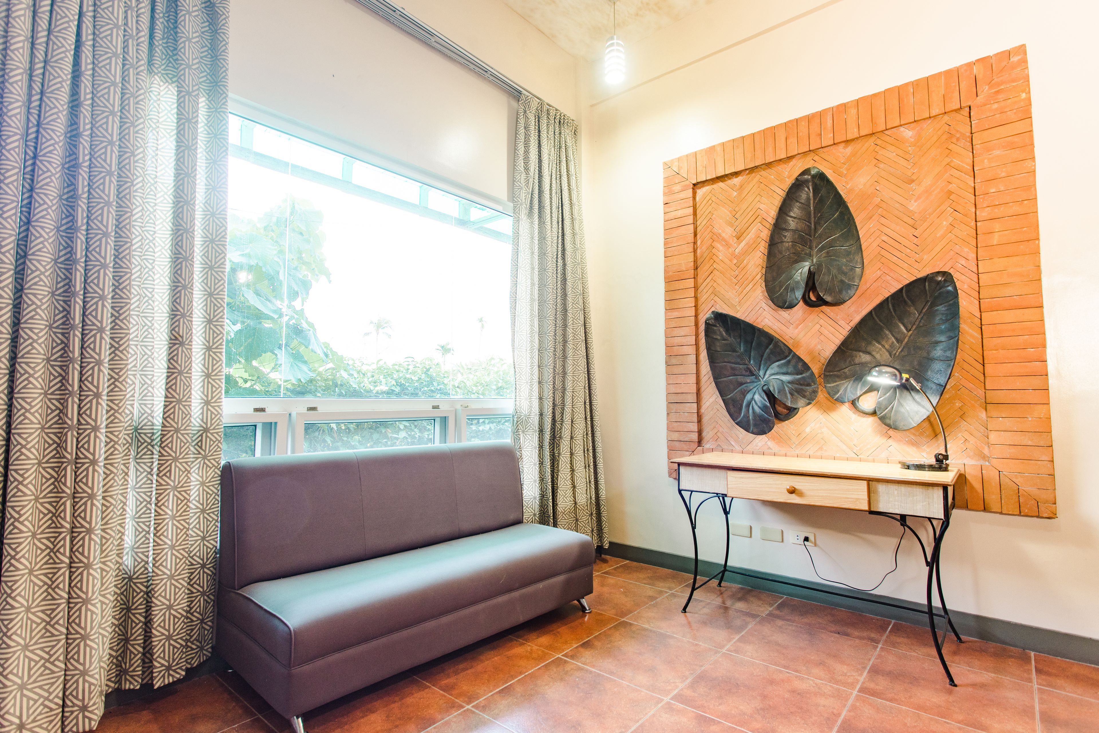Una habitación con sofá, escritorio y un cuadro de gran tamaño.
