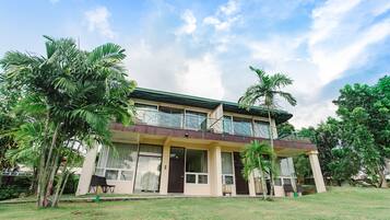 A two-story building with a flat roof, large windows, and a balcony.