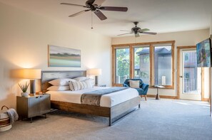 A bedroom with a bed, nightstands, a chair, and a ceiling fan.