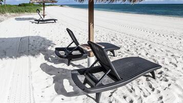 Rannalla, aurinkotuoleja, rantapyyhkeitä