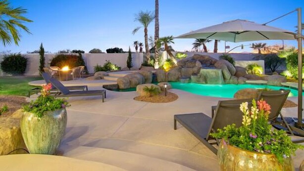 A backyard with a swimming pool, lounge chairs, and a waterfall feature. - CAMELBACK MT BEAUTY PARADISE VALLEY SCOTTSDALE AREA (Paradise Valley)