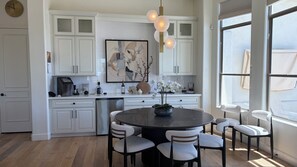 A modern kitchen with white cabinetry, a round dining table, and a large window. - CAMELBACK MT BEAUTY PARADISE VALLEY SCOTTSDALE AREA  (Paradise Valley)