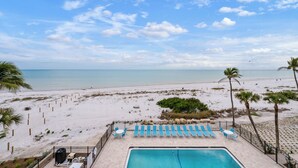A pool area with lounge chairs and a view of the beach. - OCEAN'S REACH 2B4: 1-Bdrm, Top Floor w/Gorgeous Views, All Amenities Open! (Sanibel Island)