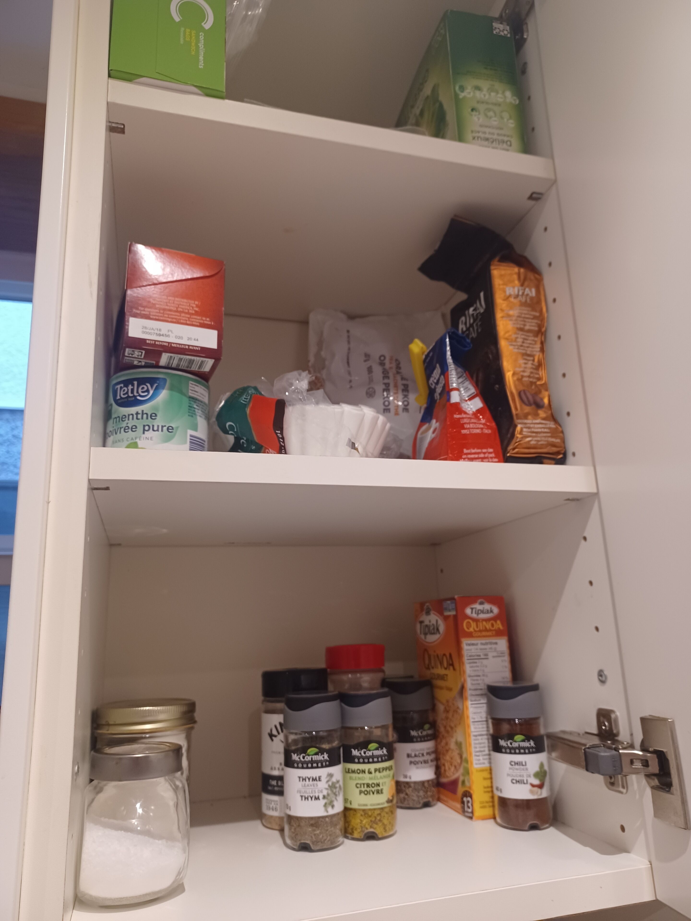 A pantry with shelves stocked with various food items, including boxes, jars, and bags.