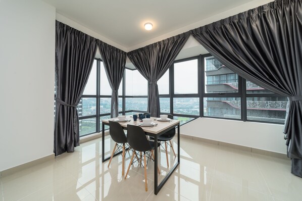 Enjoy a panoramic city view from this dining area with a large window and minimalist design.
