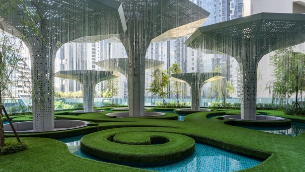 A modern outdoor area with geometric pathways, a central water feature, and tall structures with hanging elements. - OYO Home 44045 Splendid 2br Arte Plus (Kuala Lumpur)
