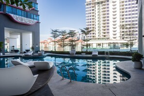 A modern hotel pool area with a clear view of surrounding high-rise buildings and a well-maintained pool with lounge chairs. - OYO Home 44045 Splendid 2br Arte Plus (Kuala Lumpur)