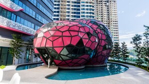 A modern building with a unique spherical structure near a pool. - OYO Home 44045 Splendid 2br Arte Plus (Kuala Lumpur)