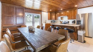 Una cocina amplia con armarios de madera, un comedor grande y electrodomésticos modernos.