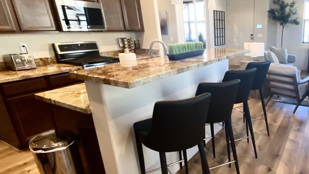 A modern kitchen with a central island, bar stools, and a stainless steel trash can. - Stunning New Contemporary Home Minutes to Downtown Flagstaff (Flagstaff)