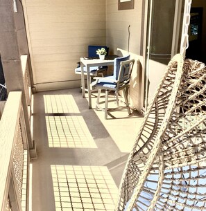 A balcony with a table and chairs, a potted plant, and a wicker chair. - Stunning New Contemporary Home Minutes to Downtown Flagstaff (Flagstaff)